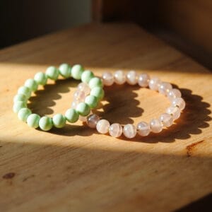 Jade and rose quartz bracelets on a surface